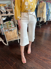 Person wearing a white pant in a store setting.