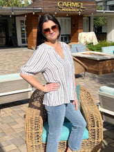 Woman sitting on a wicker chair in front of a building with 'Carmel Mission Inn' sign.