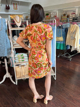 Woman wearing a floral dress in a clothing store