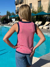 Woman wearing a red and white striped tank top by a poolside.