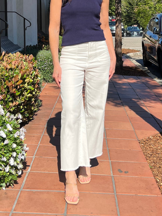 White pant with front pockets and a wide leg hem with fringe edge. Fit is slightly cropped.