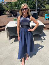 Woman in a striped dress standing outdoors on a patio
