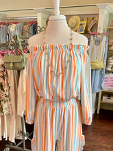 Striped off the shoulder top on a mannequin in a clothing store setting
