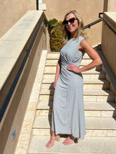 Woman in a checkered dress standing on stone steps outdoors