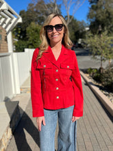 Woman wearing a red peplum jacket and sunglasses outdoors on a sunny day.