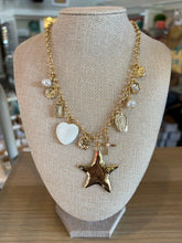 Necklace with star and heart charms on a beige bust