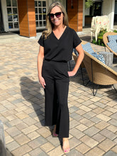 Woman in a black outfit standing on a patio