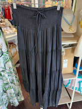 Black skirt hanging on a rack in a store setting