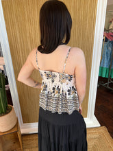 Woman wearing a floral top and black skirt in a store setting