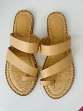 Pair of beige sandals with woven soles on a white background