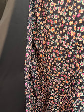 Floral patterned lining of a navy blazer showing the inside of the blazer.