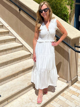 Woman in a white dress standing on stone steps outdoors