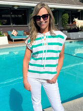 Woman wearing a green and white striped shirt by a pool