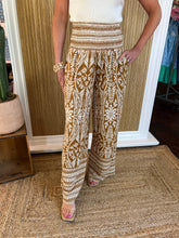 Person wearing patterned pants standing in front of a mirror.