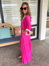 Woman in a pink dress standing on a patio