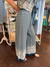 Person wearing blue patterned pants in a store setting