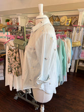 Mannequin wearing a stripe shirt with a blurred store interior in the background
