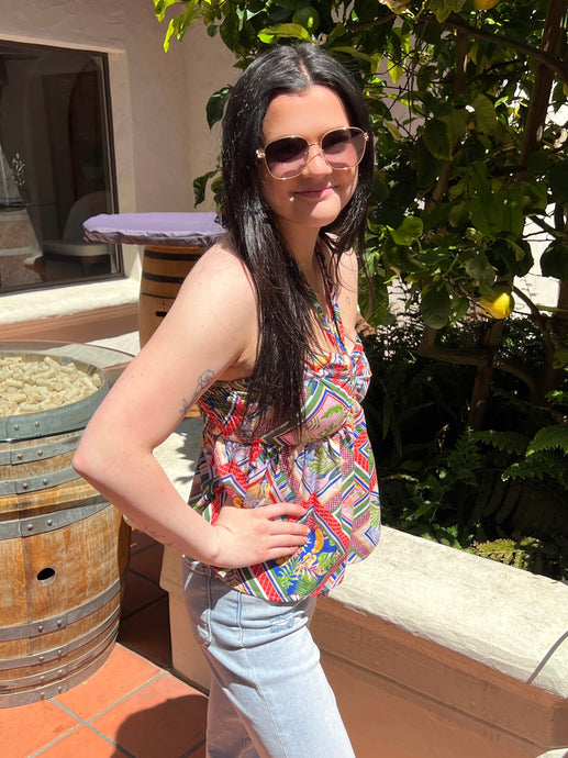 Halter style tank blouse with a multi color bold print, elastic back and peplum hem.