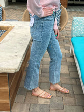 Person wearing light blue floral print jeans standing on a patio.