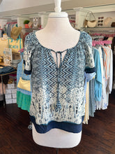 Blue and white patterned top on a mannequin in a store setting