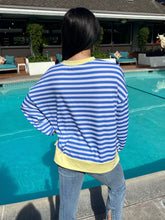 Person wearing a blue and white striped shirt by a pool