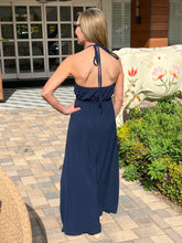 Woman in a navy blue dress standing outdoors on a patio.
