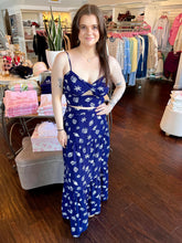 Woman standing in a store wearing a navy seashell print skirt and matching cropped tank top.