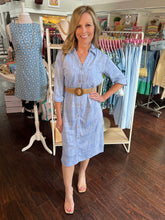 Woman wearing a blue dress in a clothing store