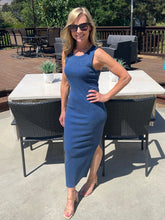 Woman in a blue dress standing outdoors on a patio
