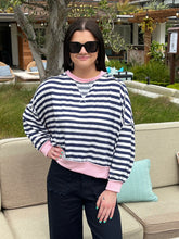 Woman wearing a striped sweater and sunglasses outdoors