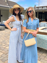 Two women in summer dresses standing on a modern patio.