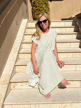 Woman in a striped dress sitting on stone steps outdoors