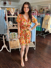 Woman in a floral dress standing in a clothing store