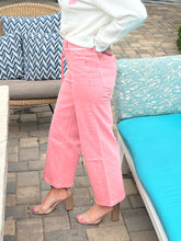 Person wearing pink pants standing on a patio with outdoor furniture.