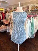 Mannequin wearing a blue dress with white patterns in a store setting