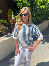 Woman wearing a striped sweater and sunglasses outdoors