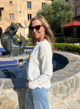 Woman standing in front of a fountain with a sculpture in a courtyard setting