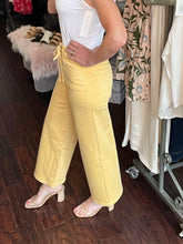 Person wearing yellow pants in a clothing store setting