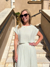 Woman in a striped dress standing on steps outdoors