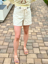 Person wearing white shorts on a paved patio