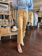 Person wearing tan pants and a blue shirt in a clothing store.