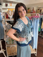 Woman wearing a patterned outfit in a clothing store