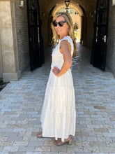 Woman in a white dress standing on a stone pathway