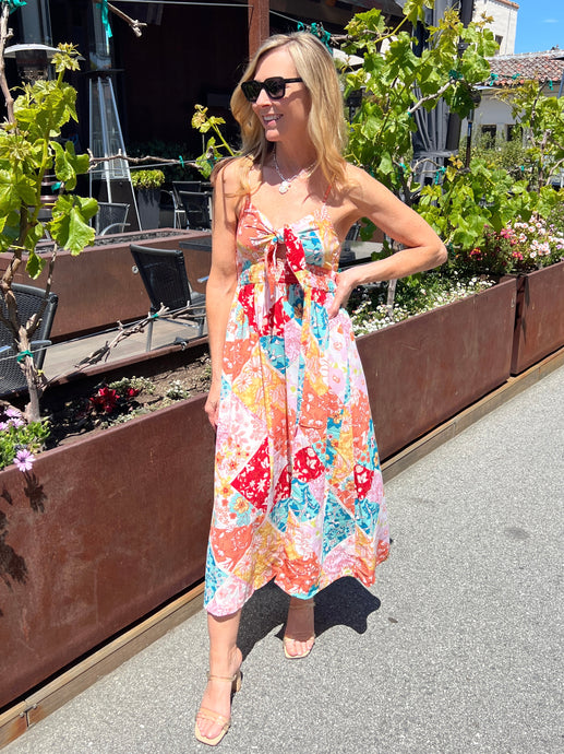 Patchwork sundress with thin straps, center chest tie, elastic waist and a midi length skirt. 