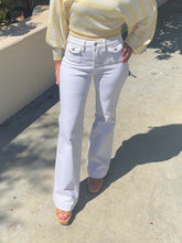 Person wearing a yellow top and white pants on a concrete surface.