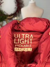 Red puffer jacket with 'Ultra Light Packable Jacket' text printed on inside of jacket neck.