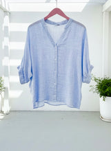 Light blue striped shirt on a hanger against a white background