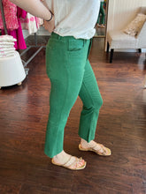 Woman wearing green jeans standing in a store.