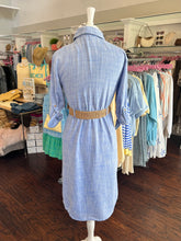 Blue shirt dress with a woven tan belt showing the back view on a mannequin in a clothing store