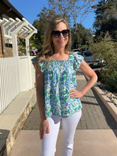 Woman wearing a floral top and sunglasses outdoors